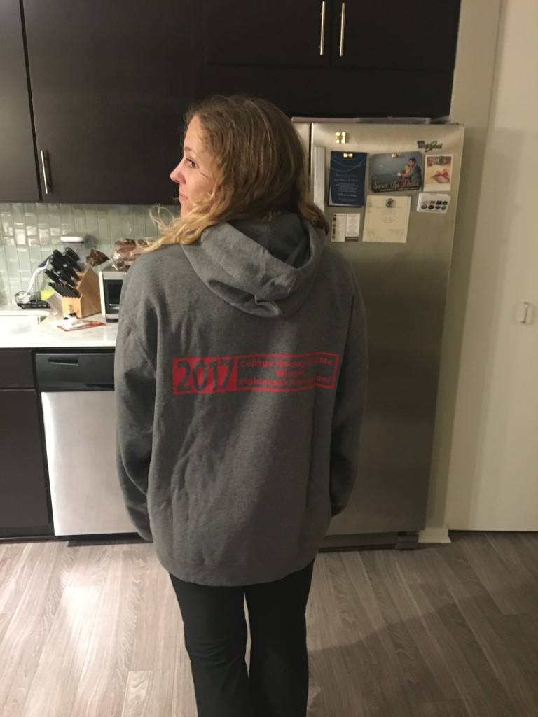 2017 College Hockey Update Pool Winner Olivia Roth models the backside of her Trophy Sweatshirt, and the official, one-of-a-kind College Hockey Update Eighteenth Annual Pool Winner Logo. Read how to succeed with what matters most in the 2017-18 College Hockey Season in today’s post. And read Olivia Roth’s candid tips that led to her success in winning it all in 2017, in her exclusive interview with The Update.